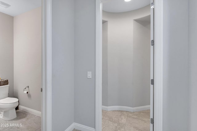 bathroom with tile patterned flooring, baseboards, visible vents, and toilet