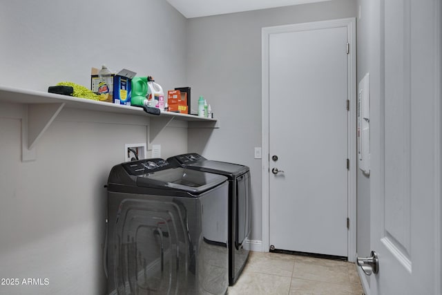 washroom with washer and dryer, laundry area, and light tile patterned floors