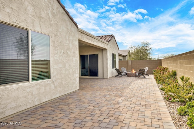 view of patio with an outdoor fire pit and fence