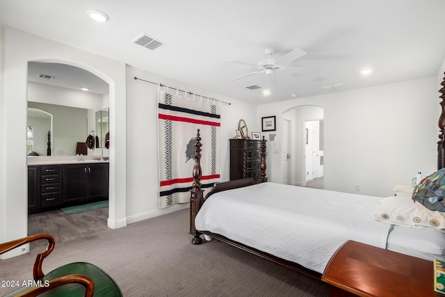 carpeted bedroom with ceiling fan and ensuite bath