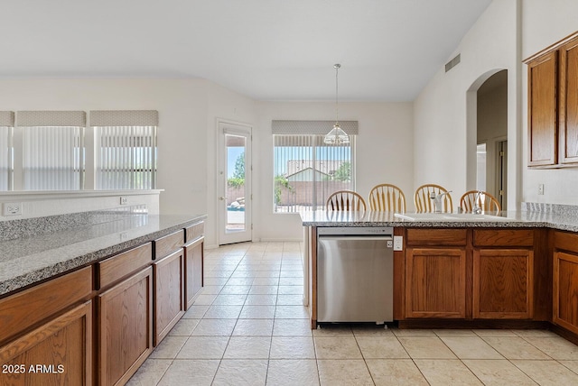 4701 W Fallen Leaf Ln, Glendale, AZ 85310 - kitchen with dishwasher, brown cabinetry, light tile patterned flooring, arched walkways, and pendant lighting