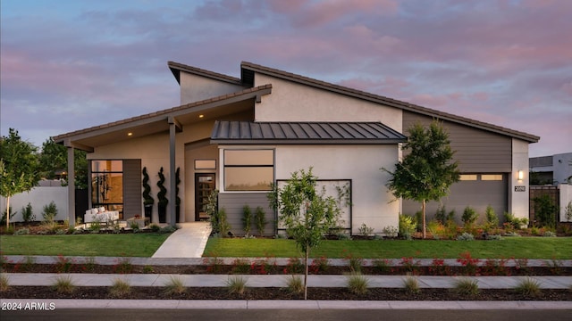 view of front of home featuring a garage and a lawn