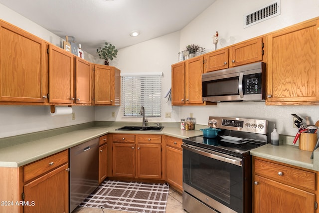 kitchen with light tile patterned flooring, stainless steel appliances, and sink