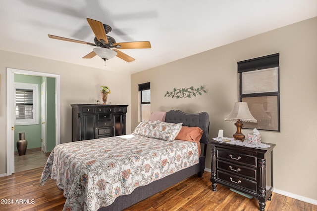 bedroom with multiple windows, dark hardwood / wood-style floors, and ceiling fan