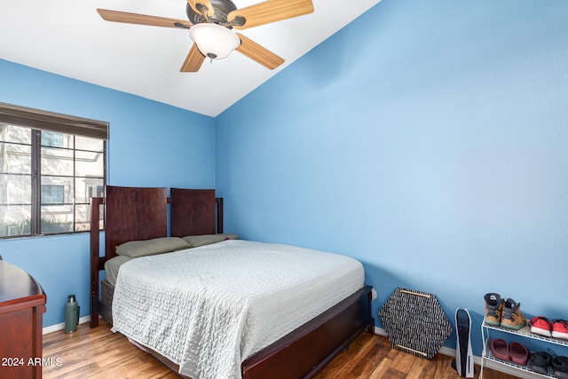 bedroom with ceiling fan, lofted ceiling, and hardwood / wood-style floors