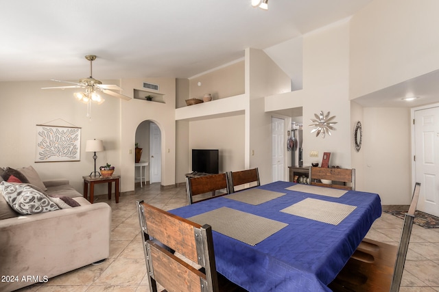 tiled dining area with high vaulted ceiling and ceiling fan