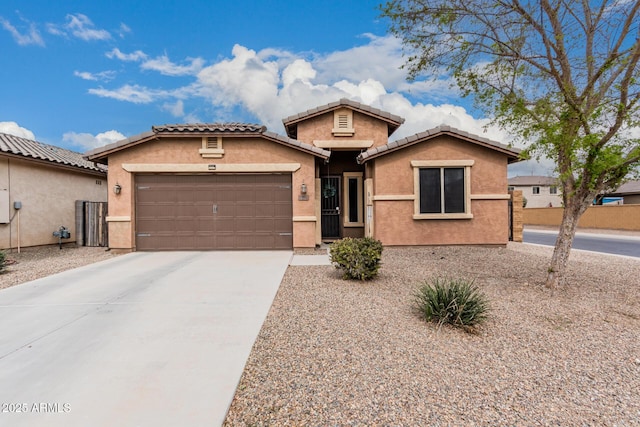 view of front of house featuring driveway, an attached garage, a tile roof, and stucco siding