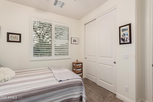 carpeted bedroom with visible vents and a closet