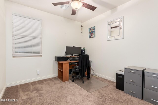 office featuring a ceiling fan, light colored carpet, visible vents, and baseboards