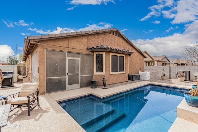 rear view of house featuring a fenced in pool, a tile roof, stucco siding, a patio area, and a fenced backyard