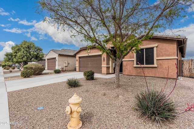 ranch-style home with stucco siding, fence, a garage, driveway, and a tiled roof