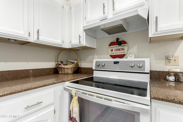 kitchen featuring white cabinets, dark stone counters, and white range with electric cooktop