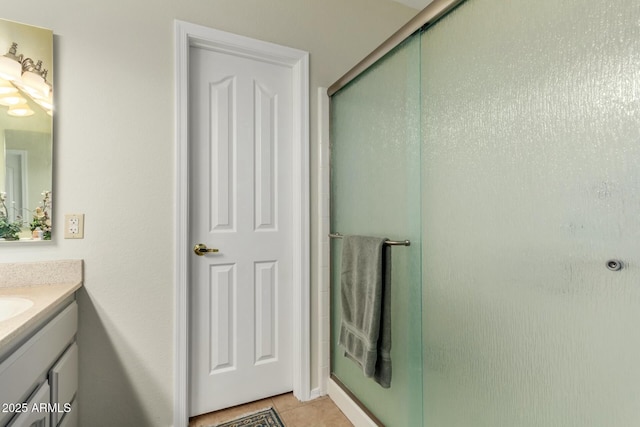 bathroom featuring vanity, a shower with shower door, and tile patterned flooring