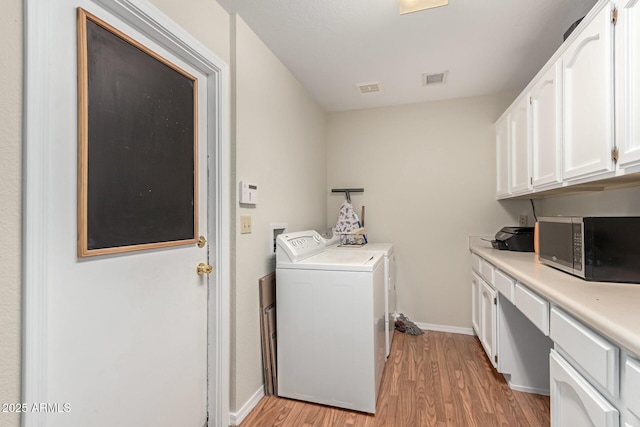 laundry room with cabinets, separate washer and dryer, and light hardwood / wood-style flooring