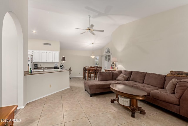 tiled living room featuring high vaulted ceiling and ceiling fan
