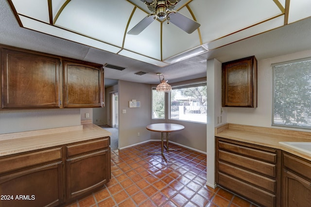 kitchen with pendant lighting, dark tile patterned floors, and ceiling fan