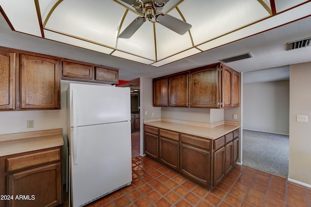 kitchen with ceiling fan, dark colored carpet, and white refrigerator