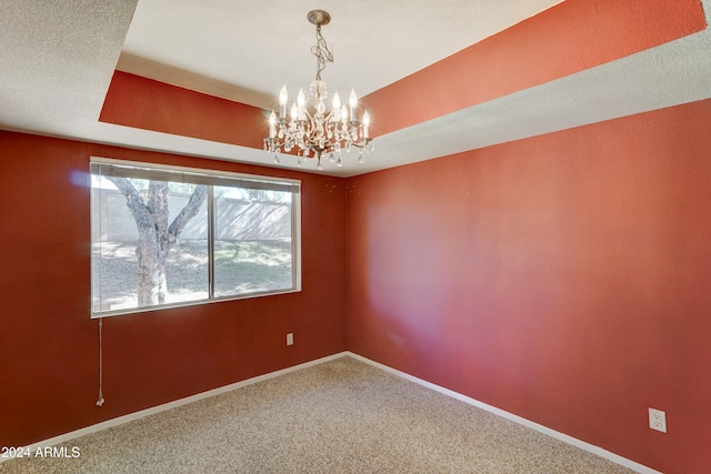 empty room featuring carpet flooring and a notable chandelier