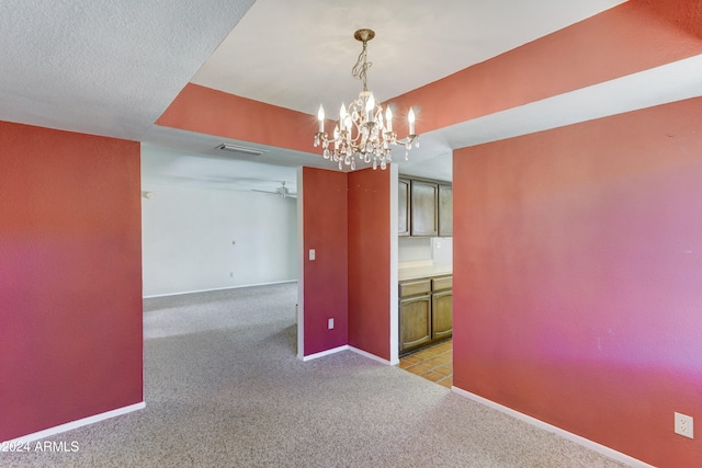 interior space with ceiling fan with notable chandelier, light colored carpet, and a textured ceiling