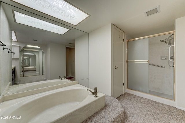 bathroom with vanity and shower with separate bathtub