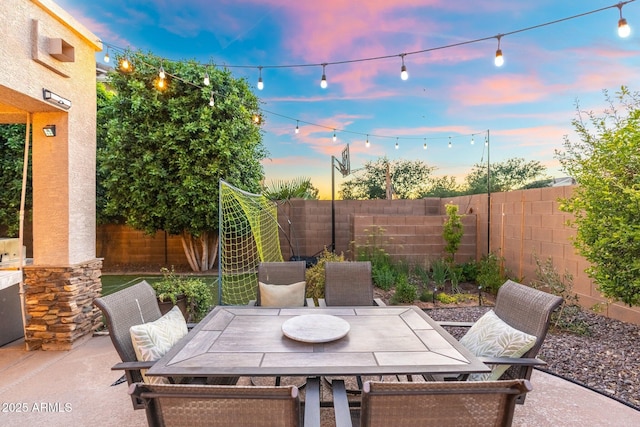 4960 E Colonial Dr, Chandler, AZ 85249 - patio terrace at dusk featuring a fenced backyard, outdoor dining space, and a patio
