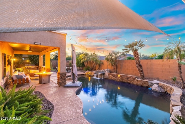 4960 E Colonial Dr, Chandler, AZ 85249 - pool at dusk with an outdoor fire pit, a fenced backyard, a ceiling fan, and a patio area