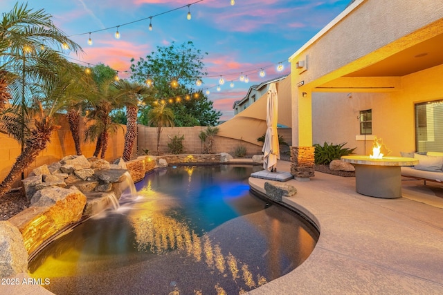 4960 E Colonial Dr, Chandler, AZ 85249 - pool at dusk with an outdoor fire pit, a fenced backyard, and a patio