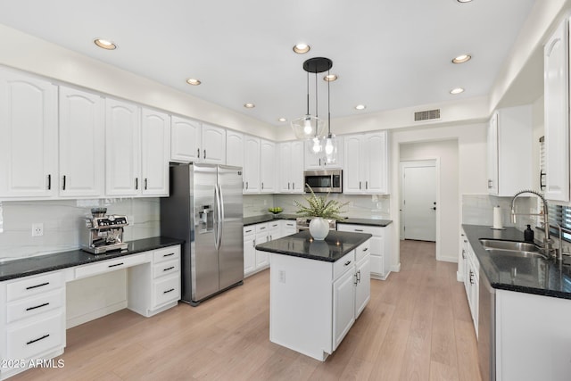 4960 E Colonial Dr, Chandler, AZ 85249 - kitchen featuring appliances with stainless steel finishes, a sink, tasteful backsplash, white cabinetry, and a kitchen island