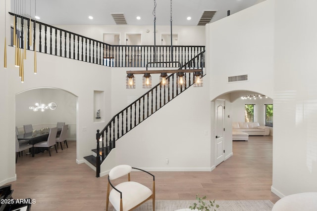 4960 E Colonial Dr, Chandler, AZ 85249 - staircase featuring arched walkways, wood finished floors, a towering ceiling, recessed lighting, and baseboards