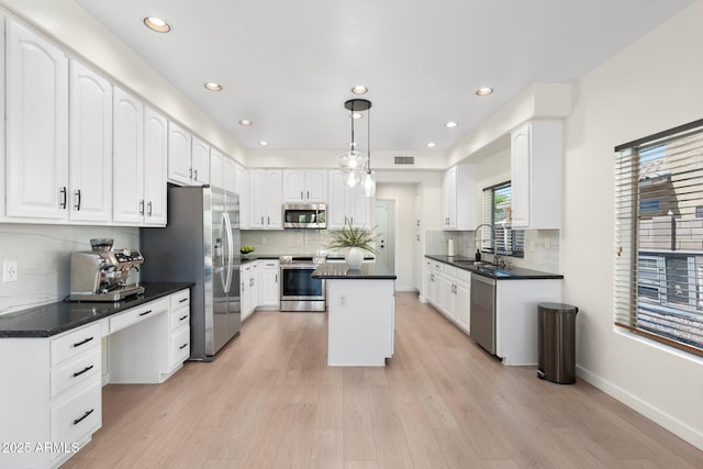 4960 E Colonial Dr, Chandler, AZ 85249 - kitchen with appliances with stainless steel finishes, white cabinetry, light wood-style flooring, backsplash, and recessed lighting