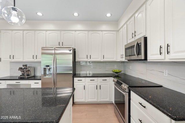 4960 E Colonial Dr, Chandler, AZ 85249 - kitchen featuring stainless steel appliances, light wood-style flooring, white cabinetry, dark stone counters, and tasteful backsplash