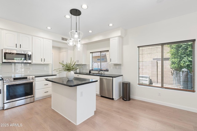 4960 E Colonial Dr, Chandler, AZ 85249 - kitchen with stainless steel appliances, a sink, a center island, decorative backsplash, and white cabinetry
