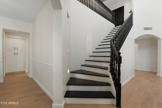 4960 E Colonial Dr, Chandler, AZ 85249 - staircase with arched walkways, wood finished floors, baseboards, a towering ceiling, and recessed lighting