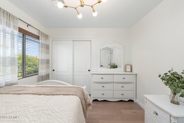 4960 E Colonial Dr, Chandler, AZ 85249 - bedroom with wood finished floors, a closet, a chandelier, and baseboards