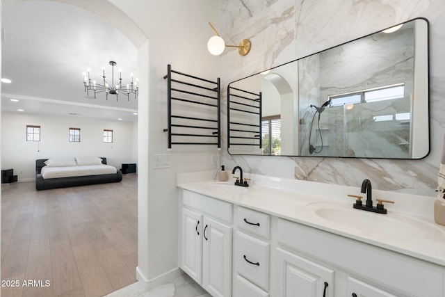 4960 E Colonial Dr, Chandler, AZ 85249 - full bathroom featuring a chandelier, a marble finish shower, double vanity, plenty of natural light, and recessed lighting