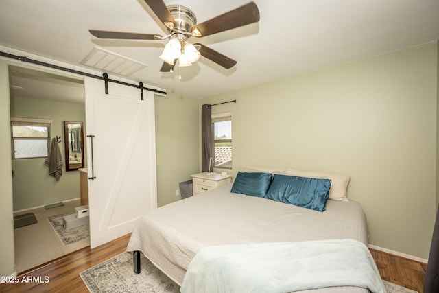 29110 N 24th Ln, Phoenix, AZ 85085 - bedroom featuring a barn door, wood finished floors, multiple windows, and ceiling fan