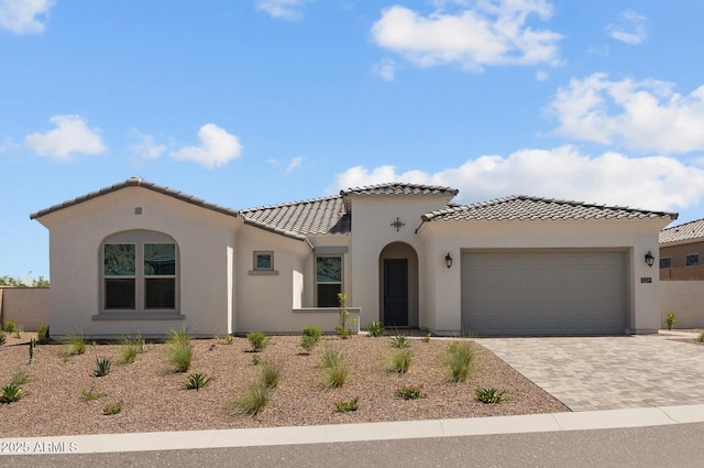 21541 W Mariposa St, Buckeye, AZ 85396 - mediterranean / spanish-style house featuring a tile roof, decorative driveway, a garage, and stucco siding
