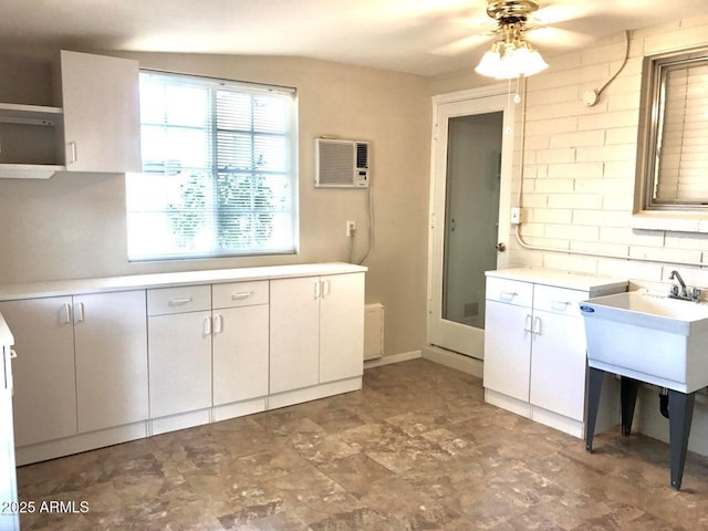 interior space with ceiling fan, sink, and a wall mounted AC