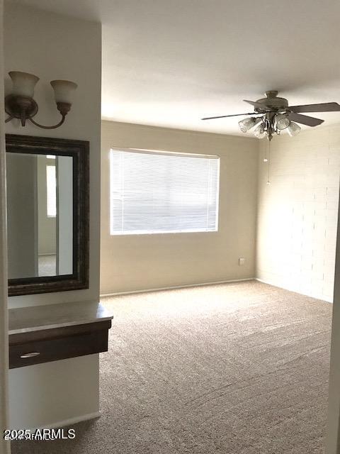 empty room with carpet flooring, ceiling fan, and a healthy amount of sunlight