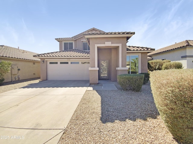 mediterranean / spanish-style home featuring driveway, a tile roof, a garage, and stucco siding