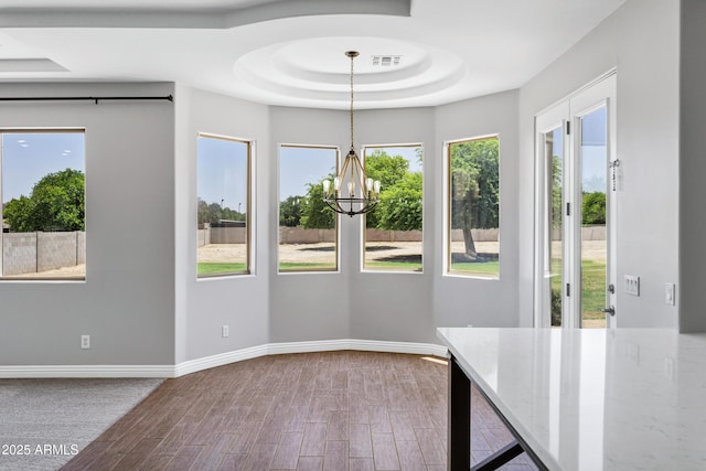 24615 S 182nd Pl, Gilbert, AZ 85298 - unfurnished dining area featuring wood finished floors, healthy amount of natural light, a tray ceiling, and a chandelier