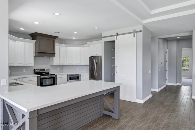 24615 S 182nd Pl, Gilbert, AZ 85298 - kitchen with stainless steel appliances, a barn door, a peninsula, dark wood-type flooring, and recessed lighting