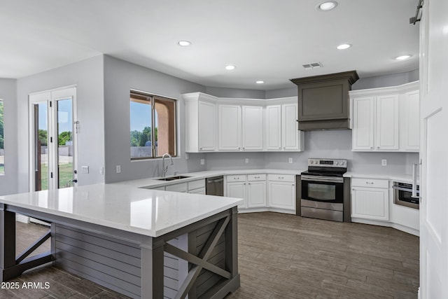 24615 S 182nd Pl, Gilbert, AZ 85298 - kitchen featuring appliances with stainless steel finishes, a peninsula, recessed lighting, dark wood-style flooring, and white cabinetry