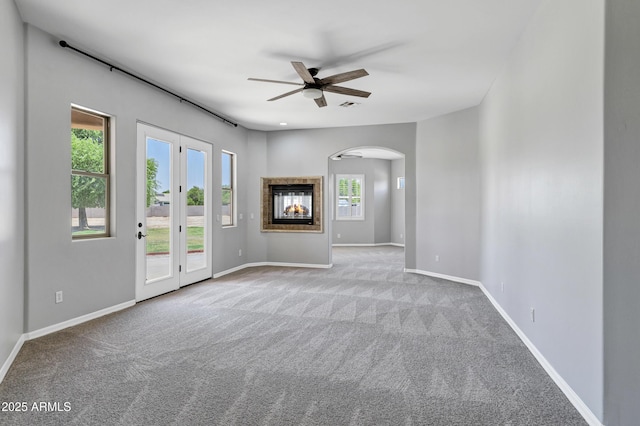 24615 S 182nd Pl, Gilbert, AZ 85298 - carpeted spare room featuring arched walkways, a ceiling fan, and a multi sided fireplace