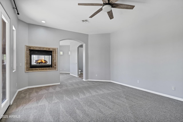 24615 S 182nd Pl, Gilbert, AZ 85298 - unfurnished living room with arched walkways, ceiling fan, carpet flooring, recessed lighting, and a multi sided fireplace