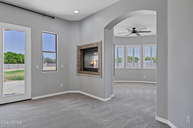 24615 S 182nd Pl, Gilbert, AZ 85298 - unfurnished living room featuring carpet flooring, a ceiling fan, healthy amount of natural light, and arched walkways