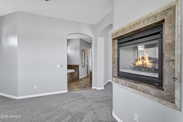 24615 S 182nd Pl, Gilbert, AZ 85298 - unfurnished living room with carpet flooring, arched walkways, and a fireplace