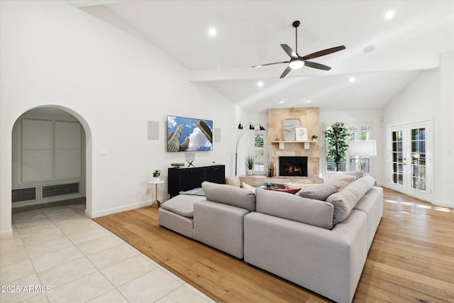 8405 E San Pedro Dr, Scottsdale, AZ 85258 - living room featuring a ceiling fan, high vaulted ceiling, arched walkways, baseboards, and a large fireplace