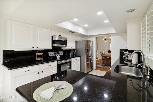 8405 E San Pedro Dr, Scottsdale, AZ 85258 - kitchen featuring stainless steel appliances, a sink, a tray ceiling, a chandelier, and white cabinets