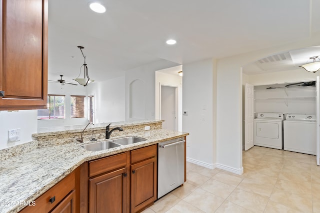 kitchen with light stone countertops, ceiling fan, sink, separate washer and dryer, and stainless steel dishwasher